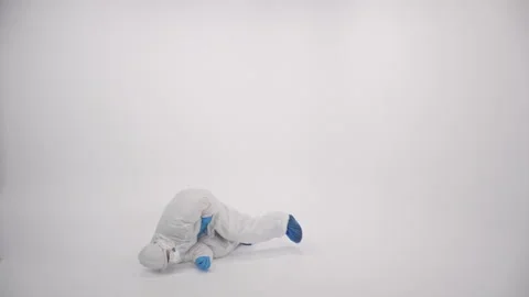 A sick scientist in PPE falling down and coming closer on a white background Stock Footage 297968646