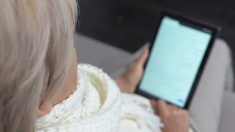 Sick senior female reading electronic book on tablet PC, seasonal epidemic Vídeo Stock 118905331