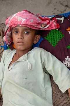 Sick weak boy lying with sad eyes in rural poverty Stock Photos