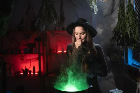Sick witch brewing a potion in cauldron suffering flu virus and hard cough... Stock Photos