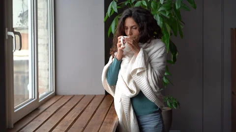 Sick woman has problem with central heating wrapped in blanket freeze drink hot Stock Footage 167939591