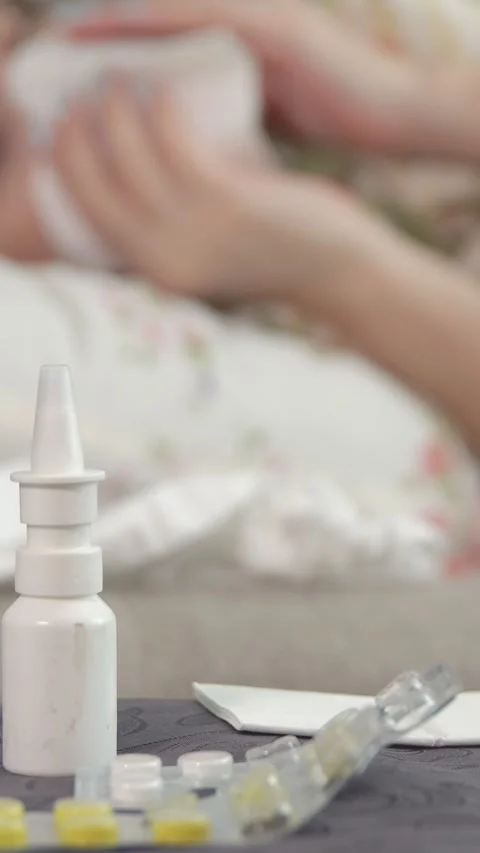 Sick woman lying in bed taking pills for flu or cold treatment with nasal spray Video stock 341678545