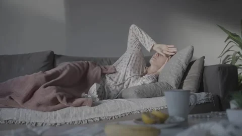 Sick woman lying on the sofa and feeling headache Stock Footage 324674985