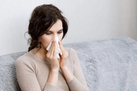Sick woman suspected of covid-19 being at home in bed sneezes. Closeup sick girl Stock Photos