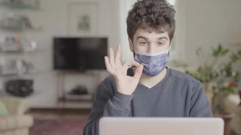 Sick worker with hygienic mask is working from home video call on laptop screen Stock Footage 126246541