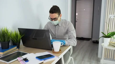 Sick worker working remote at desk, isolated. Illness man wear mask, use laptop. Stock Footage 131473029