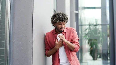 Sick young businessman coughing while standing on street near office building.  Stock-Footage 302473024