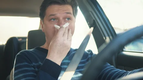 A sick young man is blowing his nose in the car Video stock 87351275