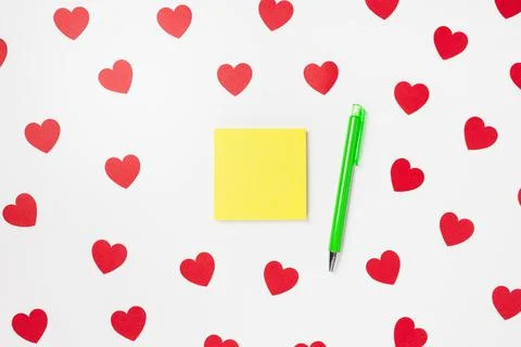 Sicky notes and pen on Valentines Day with hearts background Stock Photos