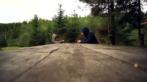 Side action view of young father and son sitting along the long wooden table nea 스톡 동영상 215862392