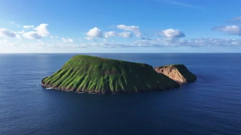 Side aerial view of Ilhéu das Cabras submarine volcano near Terceira 動画素材 329528121