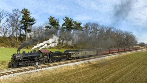 Side Aerial View of a Steam Engine Waiting, all Steamed Up, While the Engineer Foto stock