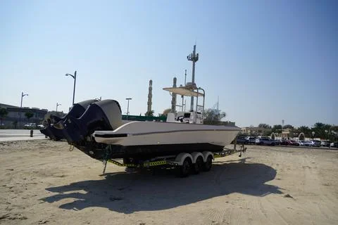 Side and close up view of a white speedboat is parked on a cart by the beach. Stockfoto's