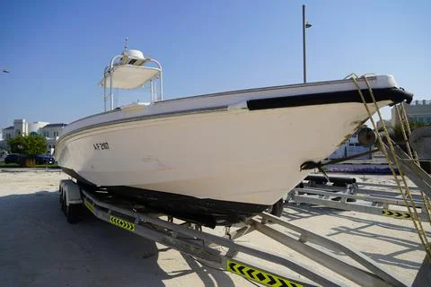 Side and close up view of a white speedboat is parked on a cart by the beach. Stockfoto's