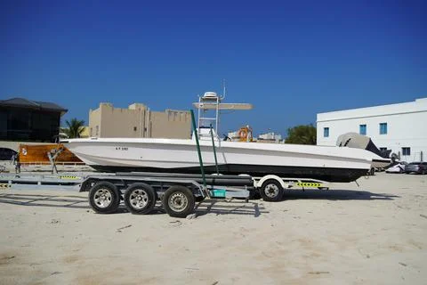 Side and close up view of a white speedboat is parked on a cart by the beach. Stock-Fotos