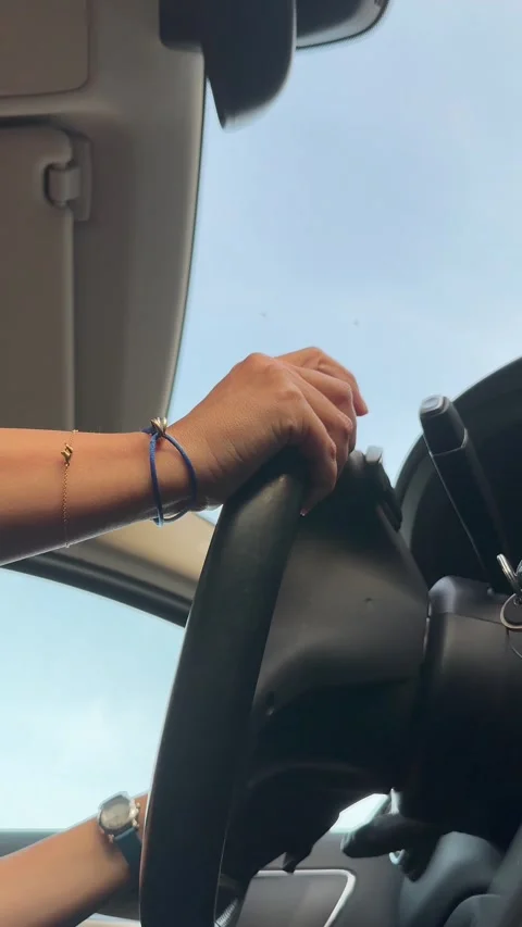 Side and Low Angle View of a Woman Driving a Car in a Sunny Day Stock Footage 265486191