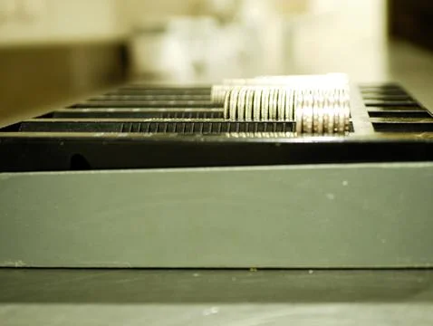 Side angle of coin stacks aligned in a black currency sorting tray Stock Photos