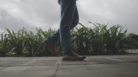 Side angle of Person walking wearing brown shoes and jeans Video stock 325433129