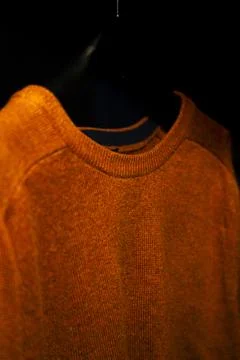 Side Angle of Plain Orange Sweatshirt on Hanger, Isolated on Black Background Foto stock