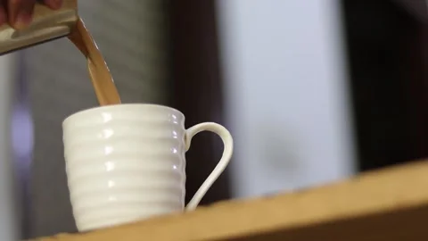 Side angle of pouring refreshing Indian tea in a cup. Early morning masala chai Stock Footage 245096285