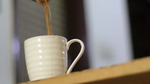 Side angle of pouring refreshing Indian tea in a cup. Early morning masala chai Stock Footage 245096361