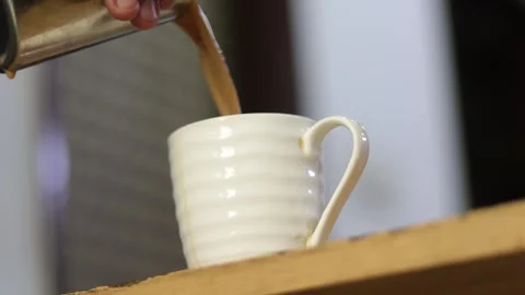 Side angle of pouring refreshing Indian tea in a cup. Early morning masala chai Stock Footage 245096363