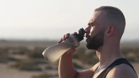Side-angle shot of athletic man drinking water during exercise break Stock Footage 132166309
