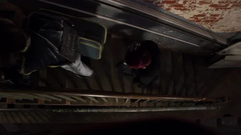 Side angle shot of people walking up the stairs in old building Stock-Footage 107618126