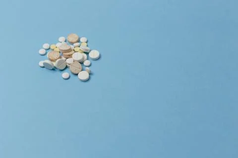 Side angle view of a bunch of various tablets lay down a light blue surface Foto stock