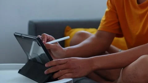 Side angle view of hands sketching on standing tablet screen while relaxing on Stock Footage 346029594