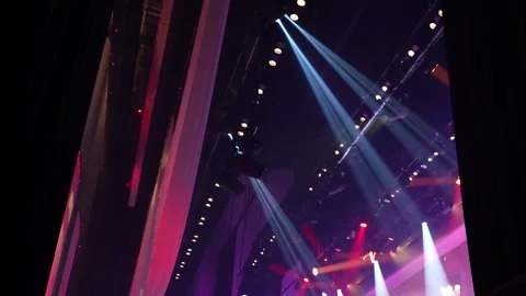 Side angle view of live concert stage with colorful lighting beams Stock Footage 346364463