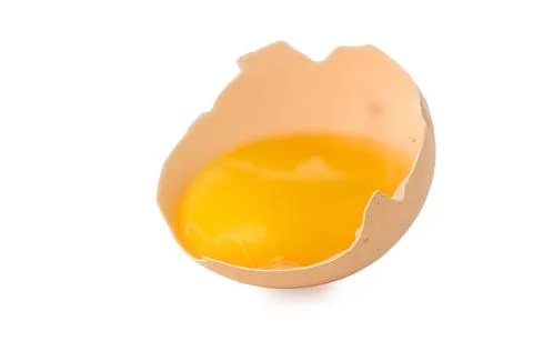 Side angle view of raw egg yolk in broken shell on white background 写真素材