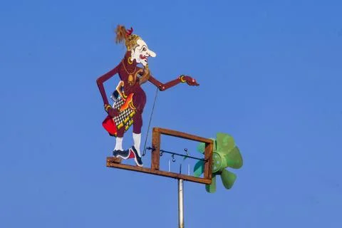 Side Angle View Of Wayang Puppet Wooden Windmill Facing Right Against Blue Sk Stock Photos
