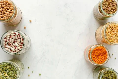 Side borders over white of jars of dried legumes Stock Photos