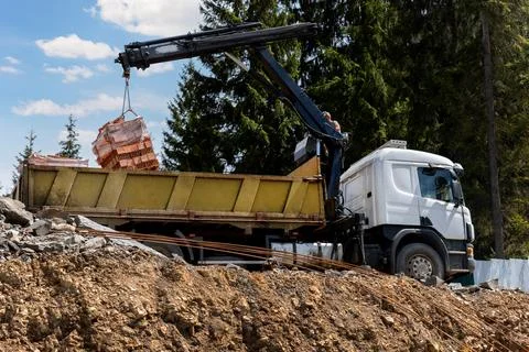 Side bottom pov big modern truck with mounted self loading crane arm boom Foto stock