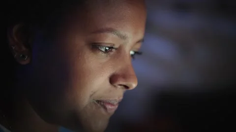 Side close-up face beautiful young American black woman looking at screen Stock Footage 256515006