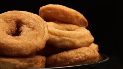SIDE-CLOSE UP: The pile of a doughnuts rotation on a black background Stock Footage 142340198
