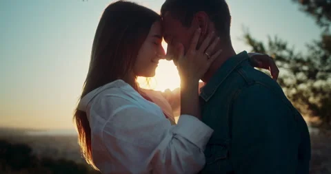 Side close up portrait shot of happy couple smiling gently touching faces at Stock Footage 140736172