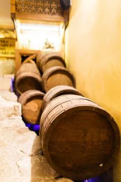 The side close-up view of the barrels lying near the walls on the brick floor Stock Photos