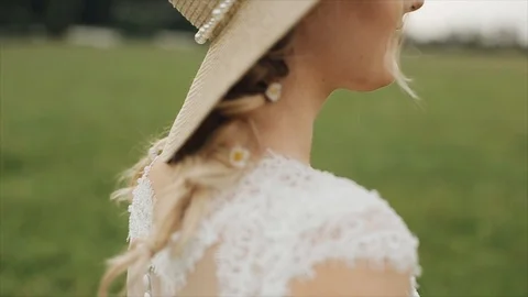 Side close view of a beautiful bride standing outdoors against blurred green 库存影片 96508319