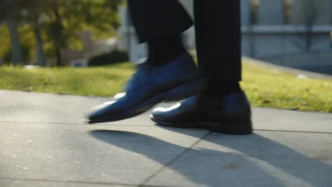 Side, close-up view to the businessman in a black new shoes walks quickly o.. Stock Footage 235377734