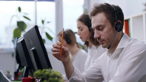 Side close up view of customer support operators with headset acting madly at Stock Footage 110836961