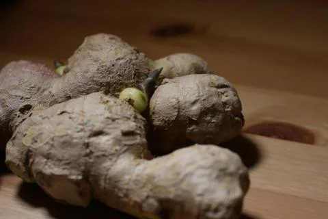 Side close up view of ginger with sprout on a wooden table Stock Photos