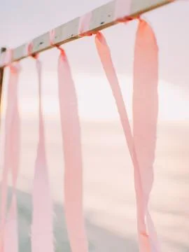 The side close-up view of the pink ribbons hanging on the wooden stick at the Stock Photos
