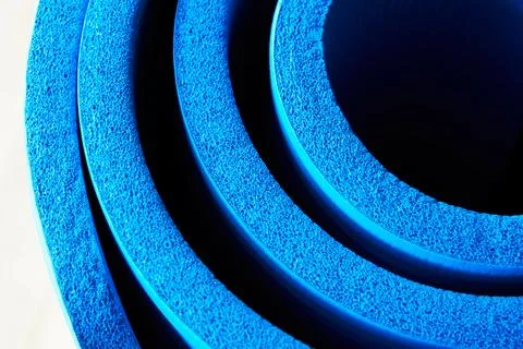 Side close up view of soft foam blue fitness rolled mat Stock Photos