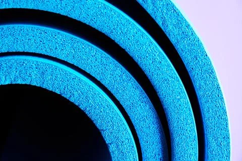 Side close up view of soft foam blue exercises rolled mat Stock Photos