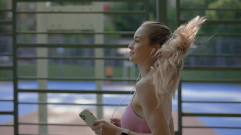 Side close view of the young beautiful woman running wearing earphones and smart Stock Footage 209123346