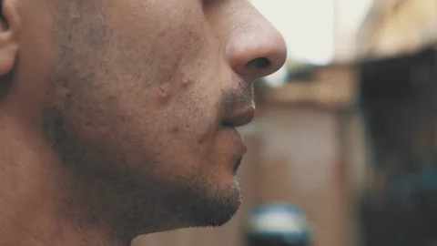 Side close-up of young man smoking cigarette Видео 277191047