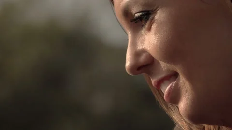 Side closeup portrait of a smiling happy young woman at sunset Stock Footage 67952762