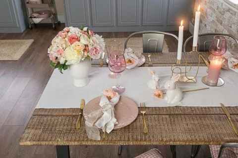 Side closeup view of romantic cute table decor with glasses flowers and lit c Foto stock